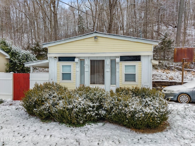 view of front of property featuring an attached carport and fence