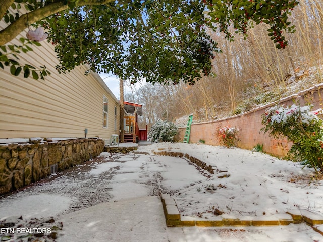 snowy yard featuring a fenced backyard