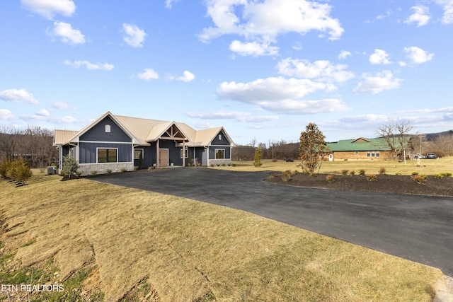 view of front of property featuring driveway, board and batten siding, and a front yard