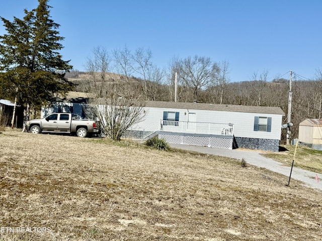 view of front of home featuring a front lawn and a wooden deck