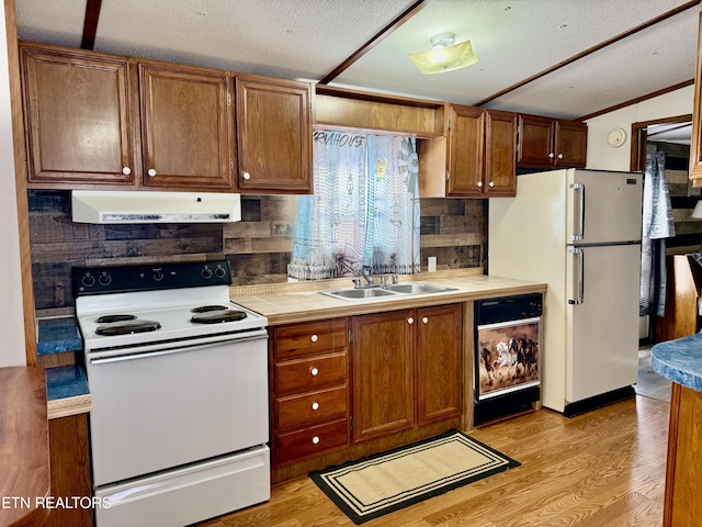 kitchen featuring extractor fan, white appliances, light countertops, brown cabinets, and light wood finished floors