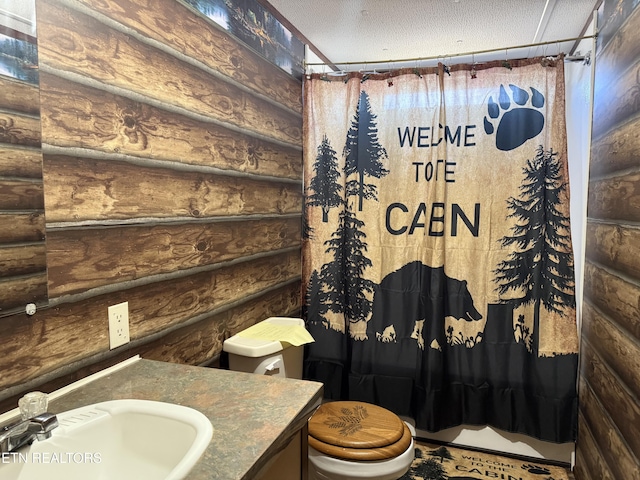 full bath featuring log walls, a textured ceiling, vanity, and toilet