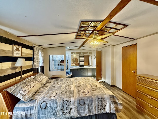 bedroom with lofted ceiling with beams and light wood finished floors