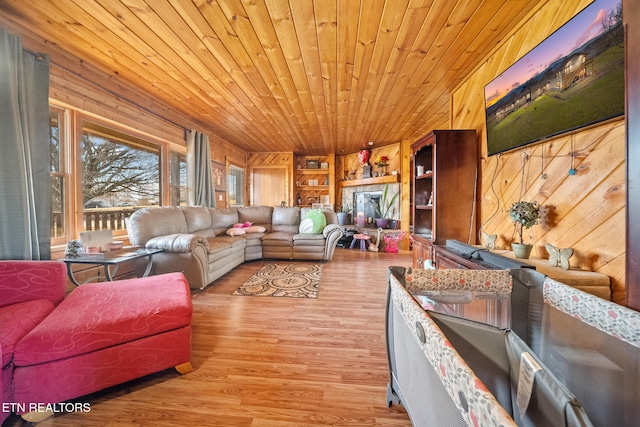 living area with built in shelves, wooden ceiling, wood walls, and wood finished floors