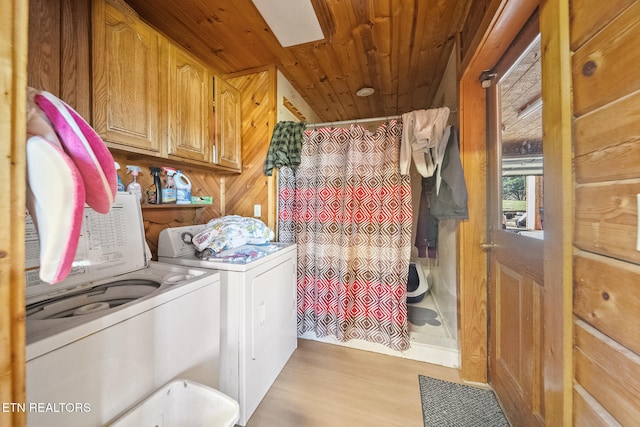 laundry room with wood ceiling, cabinet space, washing machine and clothes dryer, and wood finished floors