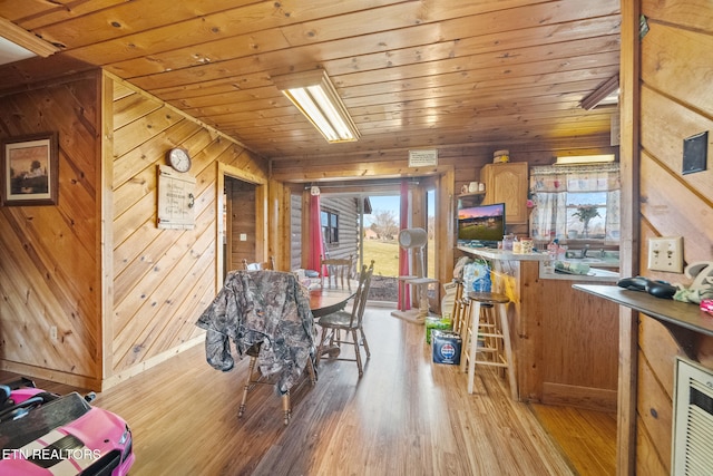 dining area featuring wood walls, wood finished floors, and wood ceiling