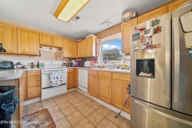 kitchen with light tile patterned floors, light brown cabinets, white appliances, visible vents, and light countertops