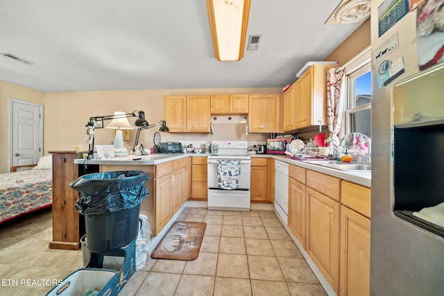 kitchen with a peninsula, white appliances, light brown cabinets, and visible vents