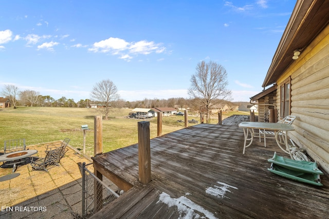 deck with an outdoor fire pit and a lawn