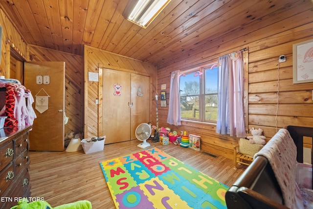 playroom with wood ceiling, wooden walls, and wood finished floors