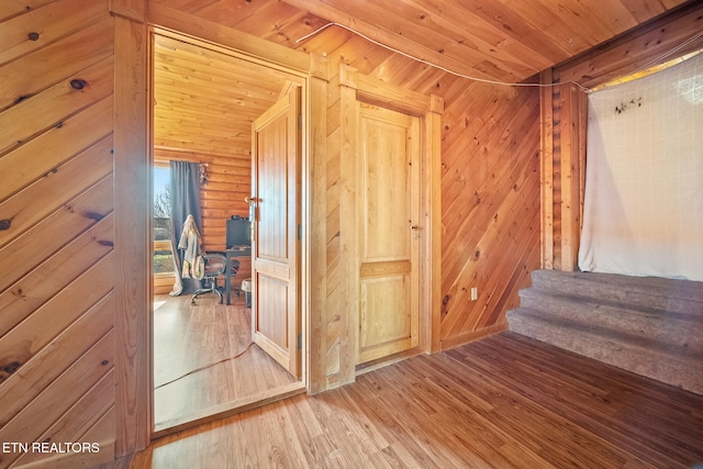 hall with rustic walls, wood finished floors, and wood ceiling