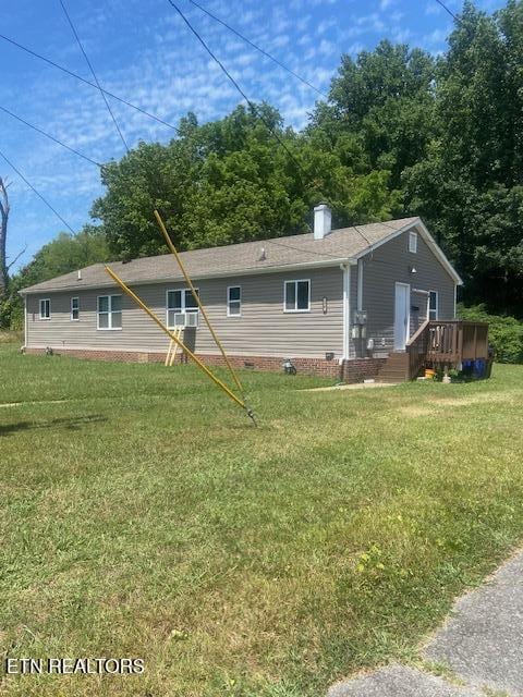 single story home with a front yard, crawl space, and a wooden deck