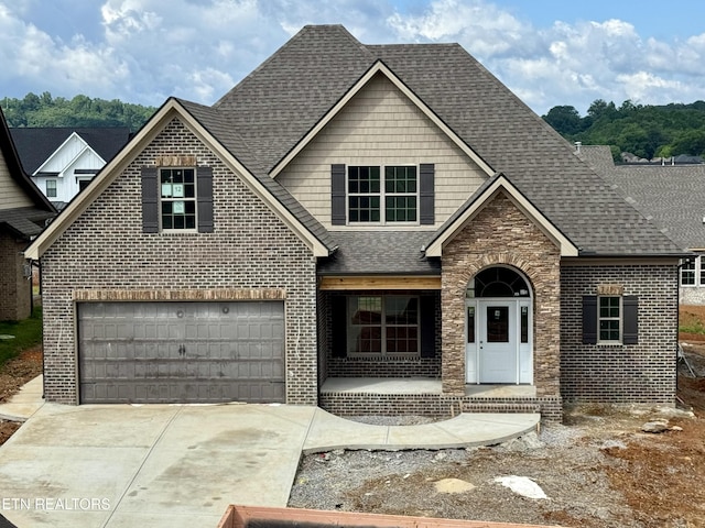 2127 Lantern Park Ln, Knoxville, TN 37932 - view of front facade featuring brick siding, a shingled roof, covered porch, driveway, and a garage