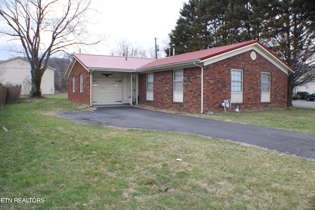 ranch-style home with metal roof, brick siding, and driveway