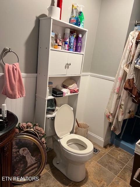 bathroom featuring a wainscoted wall, vanity, and toilet