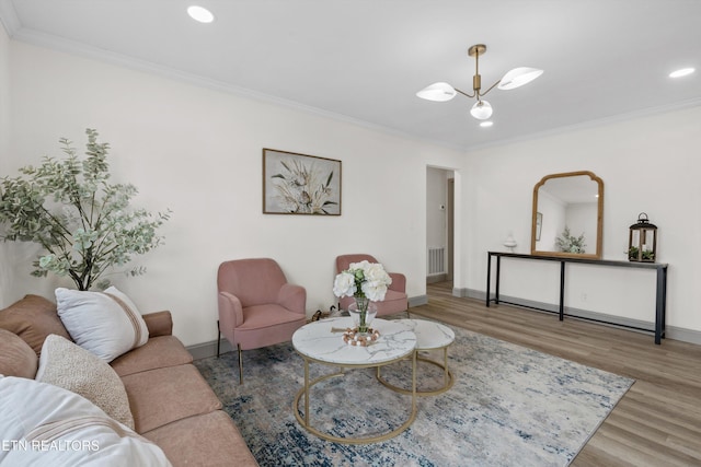 living area with visible vents, crown molding, baseboards, and wood finished floors