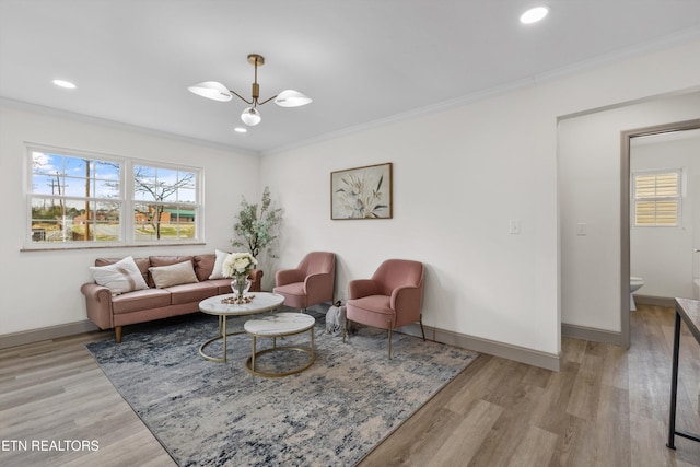 living room featuring a healthy amount of sunlight, light wood finished floors, and ornamental molding