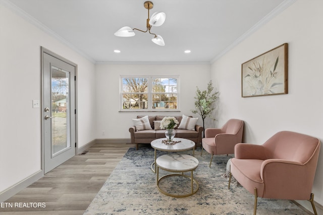 sitting room featuring a notable chandelier, light wood-style floors, a healthy amount of sunlight, and crown molding