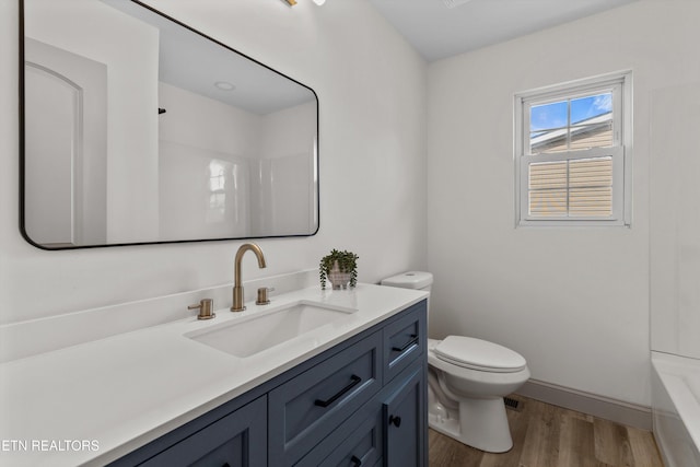 full bath with baseboards, toilet, wood finished floors, and vanity