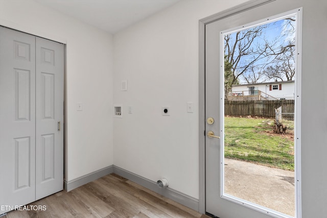 entryway with a wealth of natural light, baseboards, and light wood-style floors