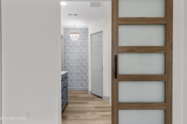 hallway featuring visible vents and light wood-type flooring