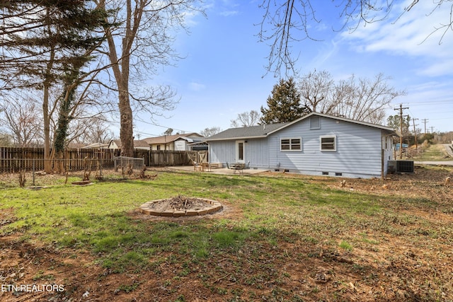 back of property featuring fence, an outdoor fire pit, cooling unit, crawl space, and a patio area