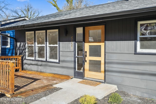 entrance to property featuring a shingled roof