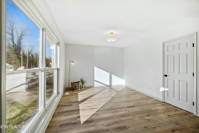 spare room featuring baseboards and wood finished floors