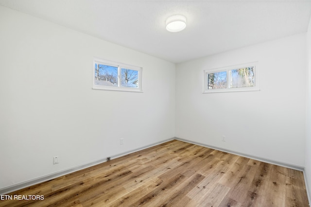 empty room with baseboards and light wood finished floors