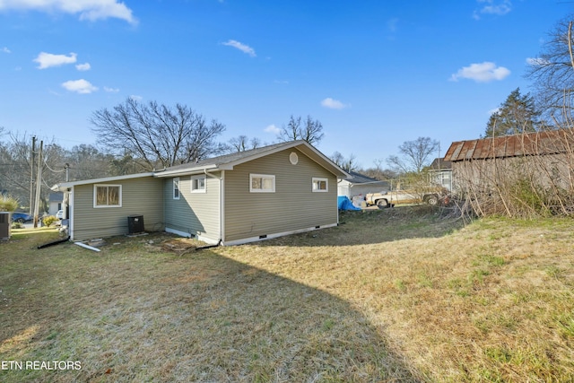 rear view of house with crawl space, central air condition unit, and a lawn