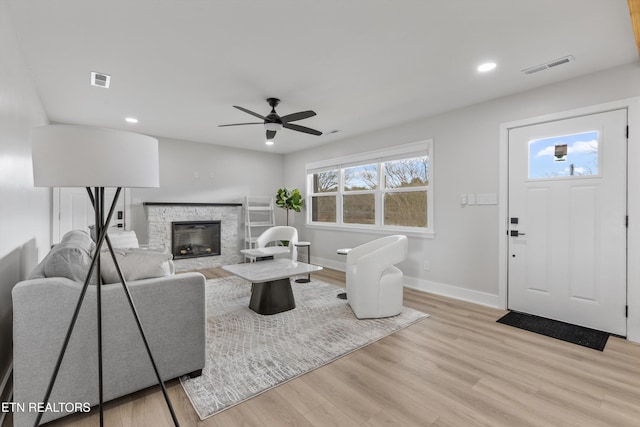 living room featuring light wood finished floors, visible vents, a healthy amount of sunlight, and baseboards