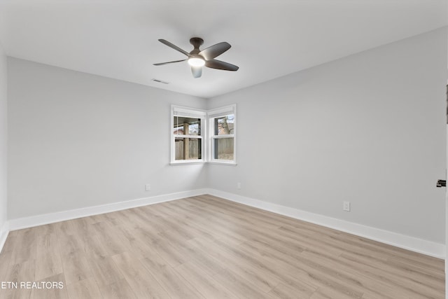 empty room featuring ceiling fan, baseboards, visible vents, and light wood-type flooring