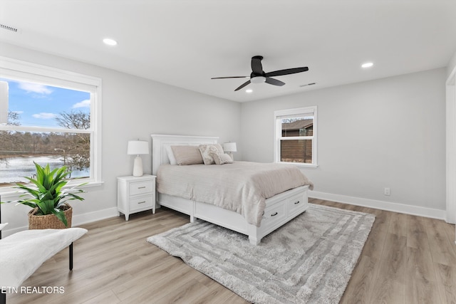 bedroom featuring visible vents, multiple windows, and wood finished floors