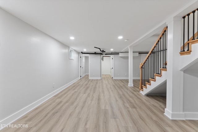 finished basement with stairs, recessed lighting, baseboards, and light wood finished floors