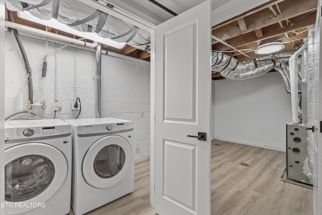 clothes washing area featuring laundry area, washer and dryer, and light wood-style flooring