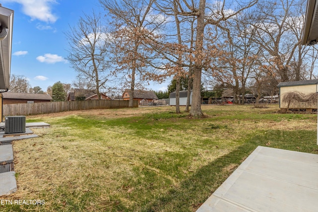 view of yard with an outbuilding, central AC unit, a patio, and fence