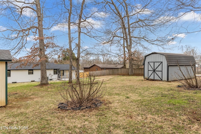 view of yard with an outbuilding, a shed, and fence