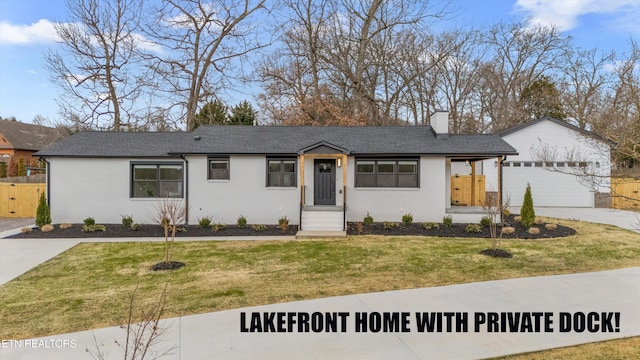 view of front of home featuring concrete driveway, a chimney, a front lawn, and fence