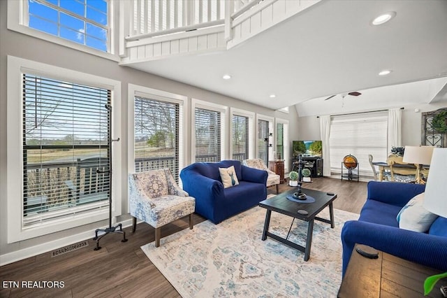 living area featuring visible vents, baseboards, a towering ceiling, wood finished floors, and recessed lighting