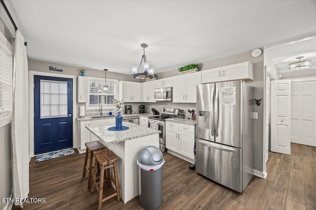 kitchen with white cabinetry, a kitchen island, pendant lighting, and stainless steel appliances