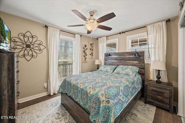 bedroom featuring ceiling fan, baseboards, and wood finished floors