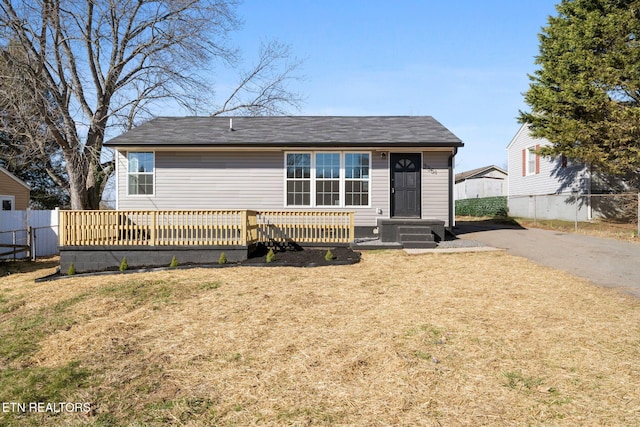 rear view of property featuring fence and a yard