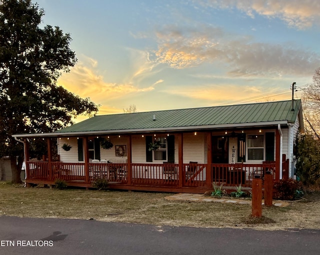 view of front facade featuring a porch and metal roof