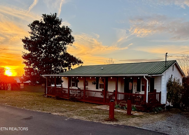 view of front facade featuring covered porch and metal roof