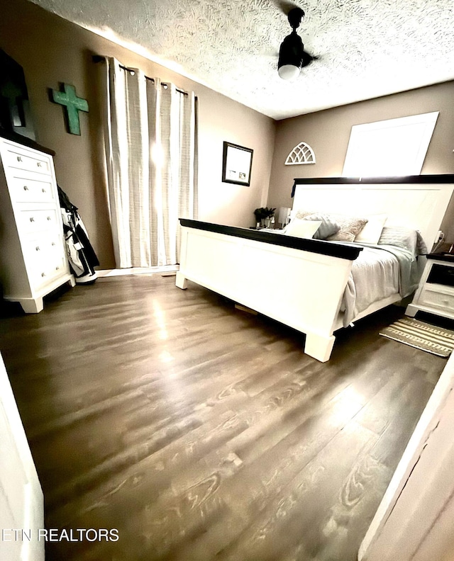 unfurnished bedroom with dark wood-type flooring and a textured ceiling