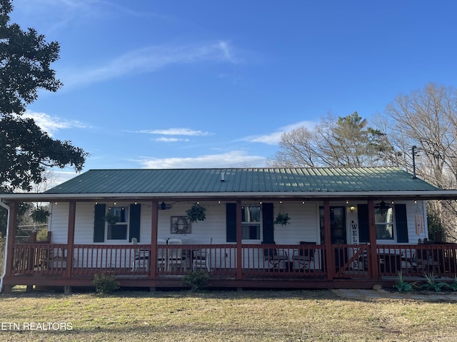 view of front of property featuring metal roof, a porch, and a front lawn