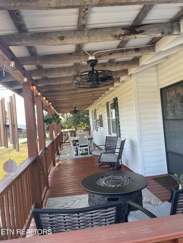 wooden deck with outdoor dining area and a ceiling fan