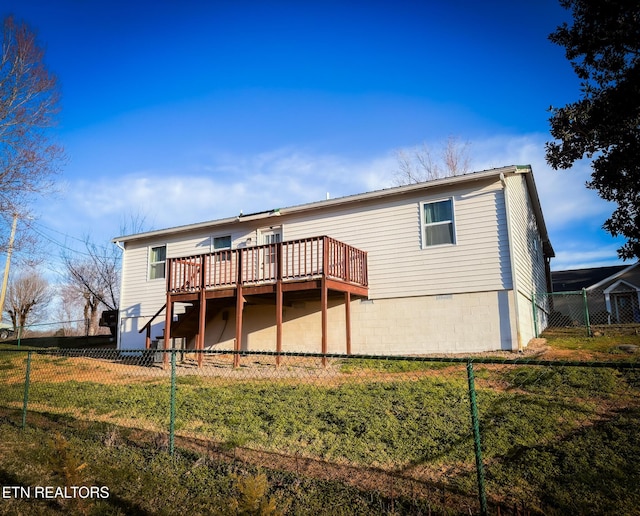 rear view of property featuring a fenced backyard, a yard, and a deck