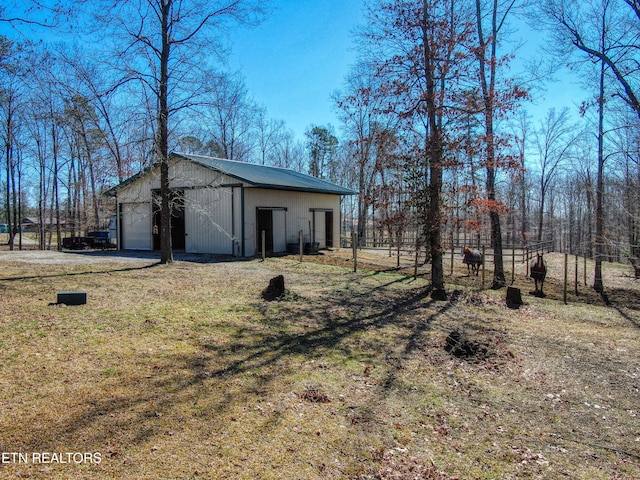 view of yard featuring an outbuilding, a pole building, and a garage