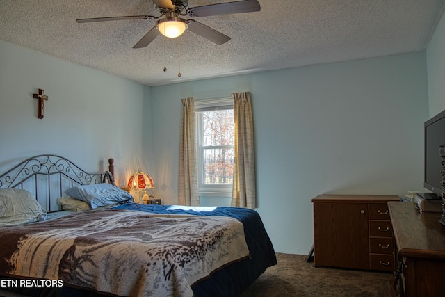 bedroom featuring a ceiling fan, dark colored carpet, and a textured ceiling